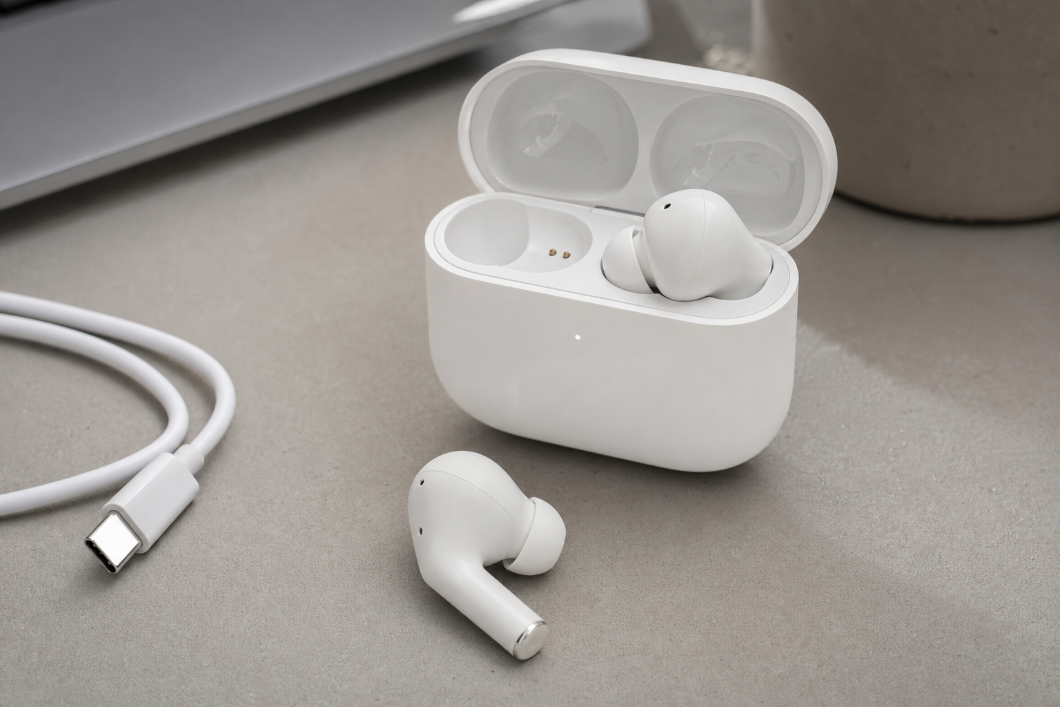 Close-up of white wireless earbuds with USB-C charging cable