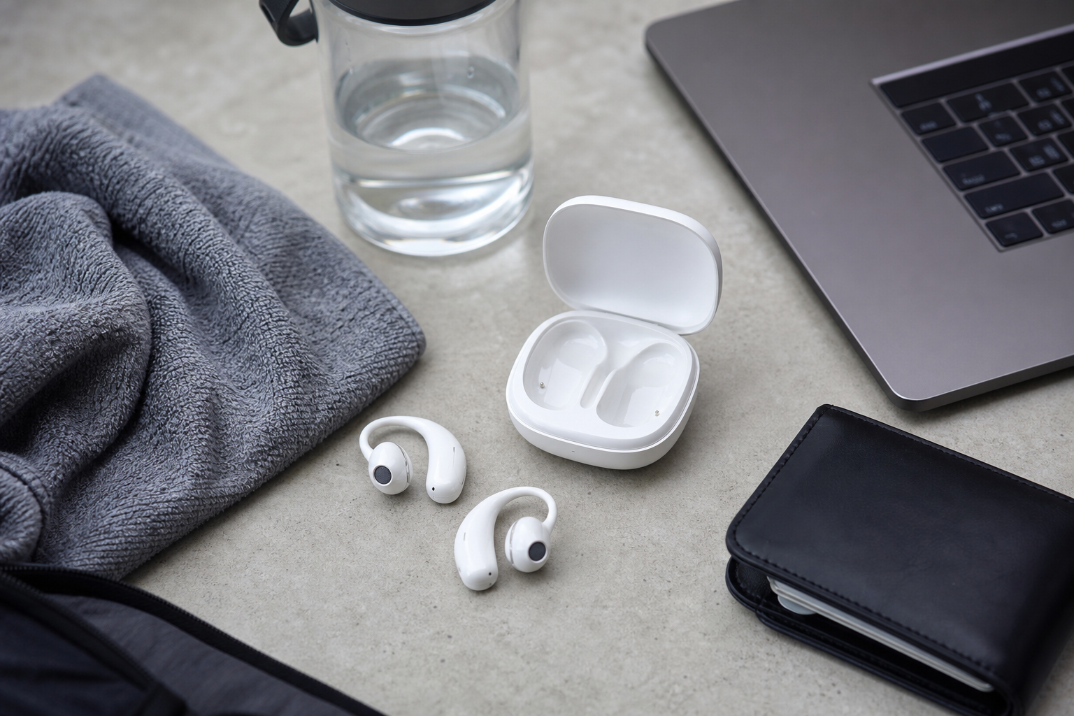 Open-fit wireless earbuds with workout and work items on a desk