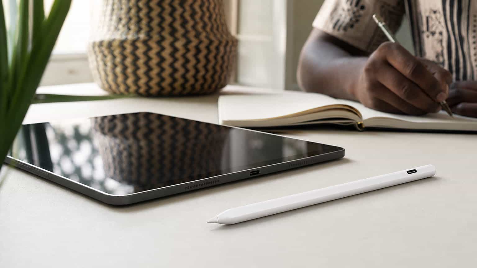 A USB-C tablet stylus beside a modern tablet on a clean desk