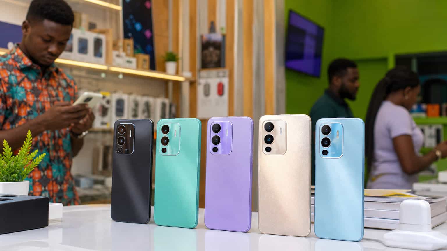 Colorful budget smartphones displayed in a Nigerian phone shop for an Infinix HOT 70 buyer guide