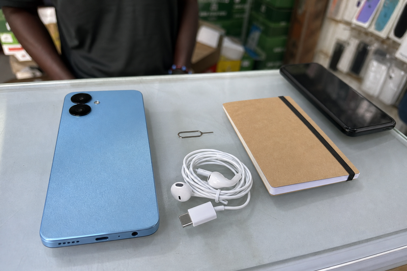 Budget smartphone on a Nigerian retail counter with accessories and comparison phone nearby