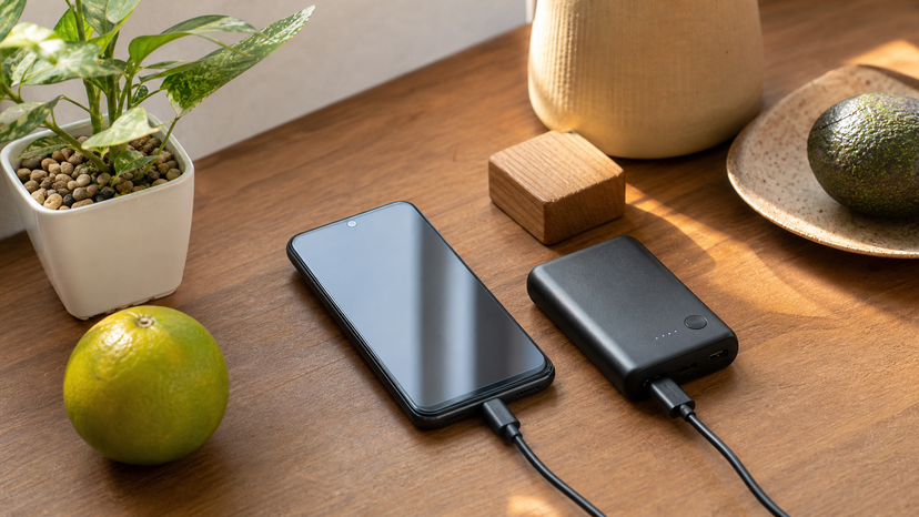 Tecno Pop 8 camera and battery trade-off visual with phone beside power bank and simple photo props
