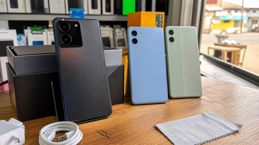 Comparison desk scene showing a premium Xiaomi phone beside Redmi alternatives without readable text