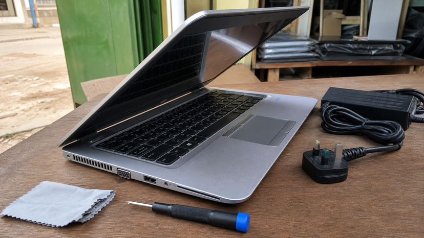 Close view of a used 14-inch business laptop showing keyboard, hinge and charger inspection points